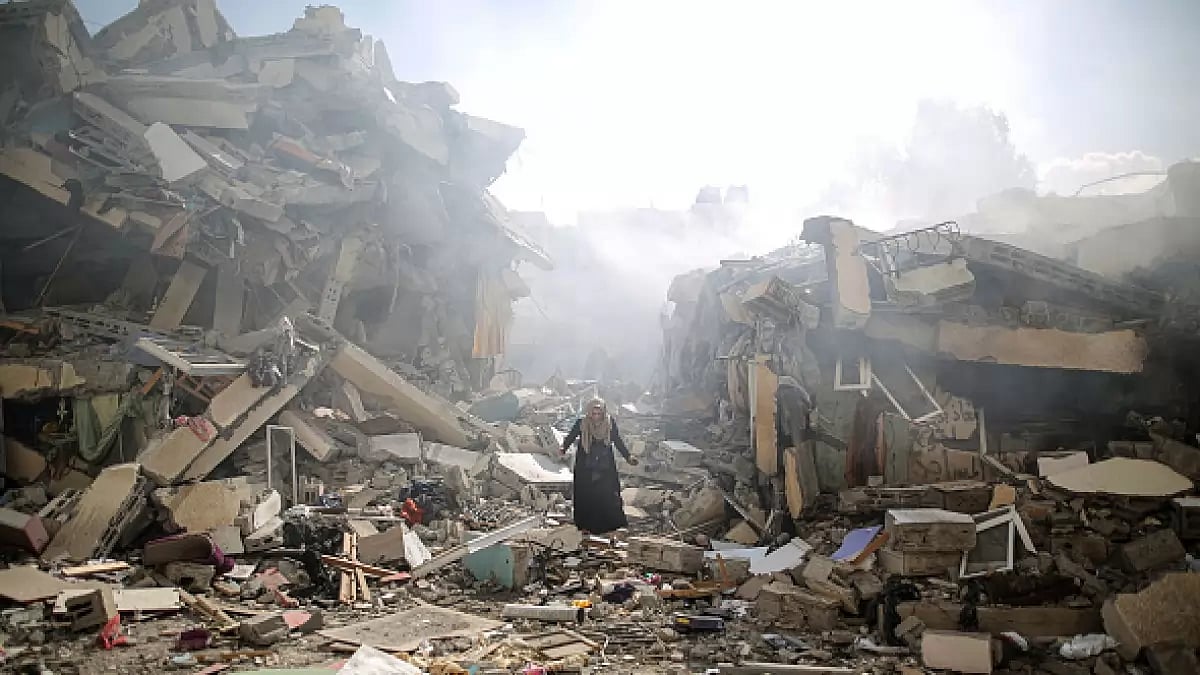 A resident gets upset as she walks amid near the rubble of residential buildings after Israeli airstrikes at al-Zahra neighborhood in Gaza Strip.
