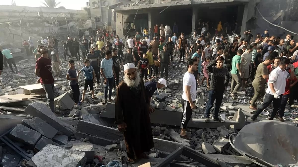 Palestinians look for survivors following an Israeli airstrike in Khan Younis refugee camp