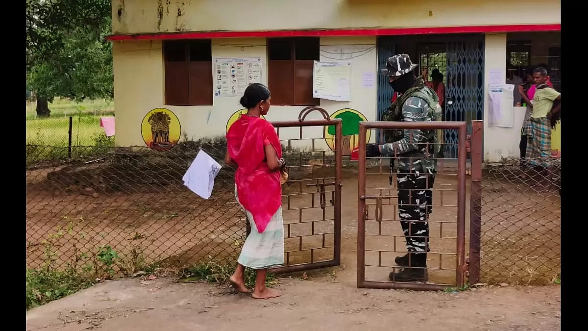 A voter in Dantewada enters a heavily guarded poll booth in Bastar, Chhattisgarh