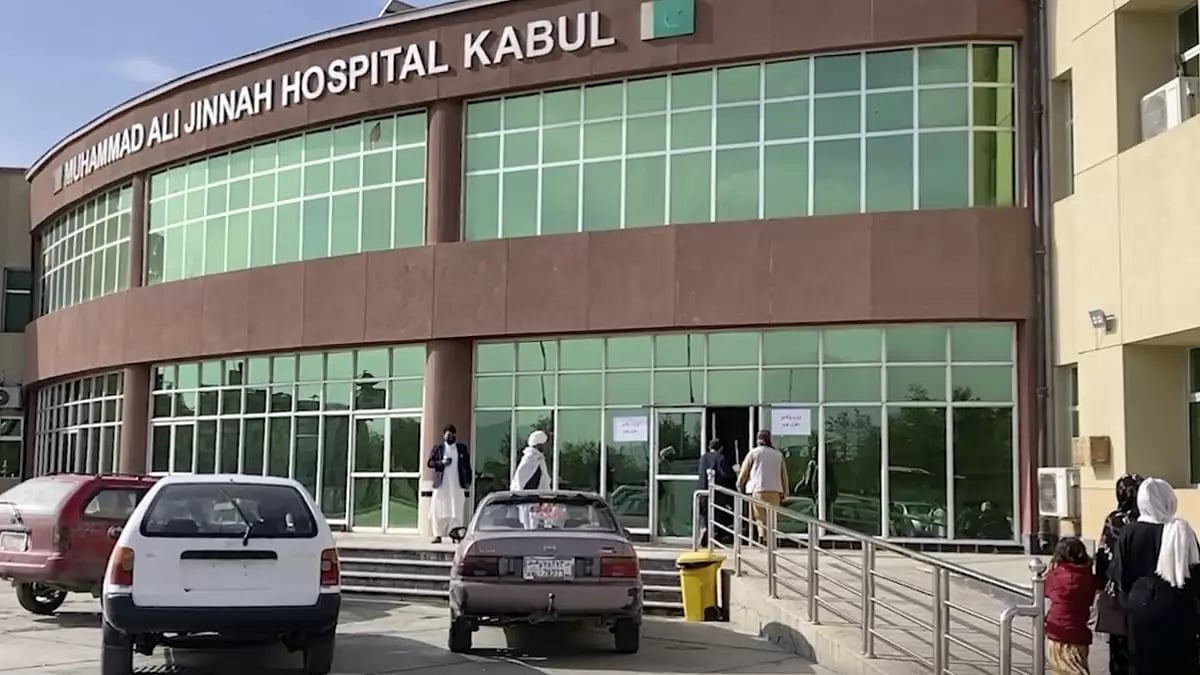 People stand in front of a hospital after a bomb explosion in the west of Kabul