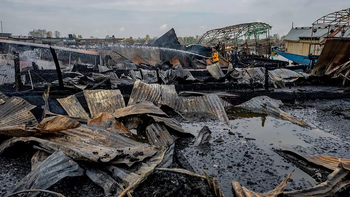 Kashmiris work to douse a fire that gutted several houseboats early morning in the interiors of Dal Lake, on the outskirts of Srinagar, Kashmir.