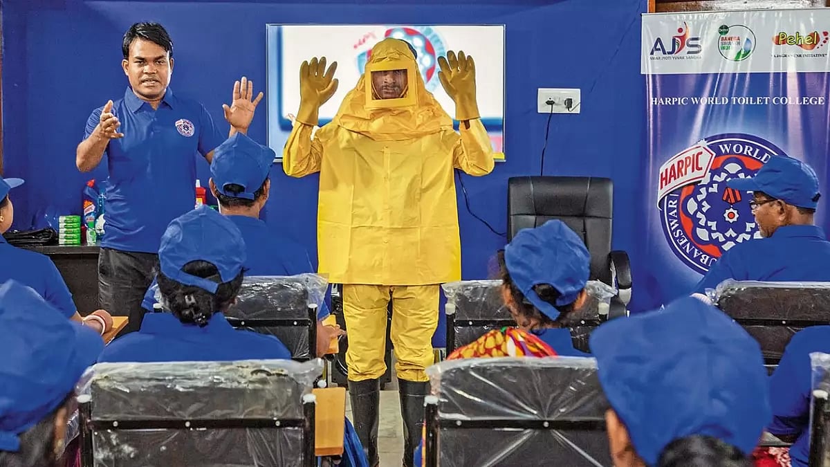 Sanitation workers attend a lecture on training in safety at a Harpic World Toilet College 