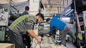 Workers at a printing press on a chilly November night in Srinagar