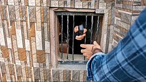 Redacted: A Kashmiri man helps another to speak on a landline phone as cell phones and internet services were suspended