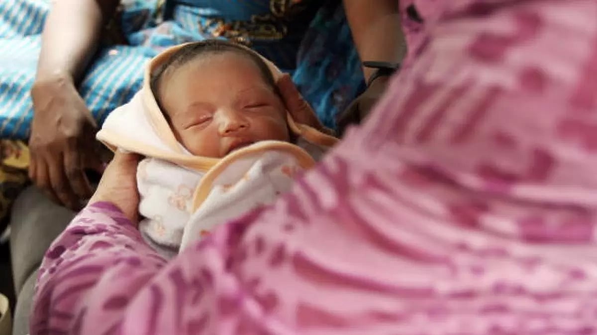 Japanese baby Manji Yamada is held by her grandmother in a vehicle in front of India's Supreme Court