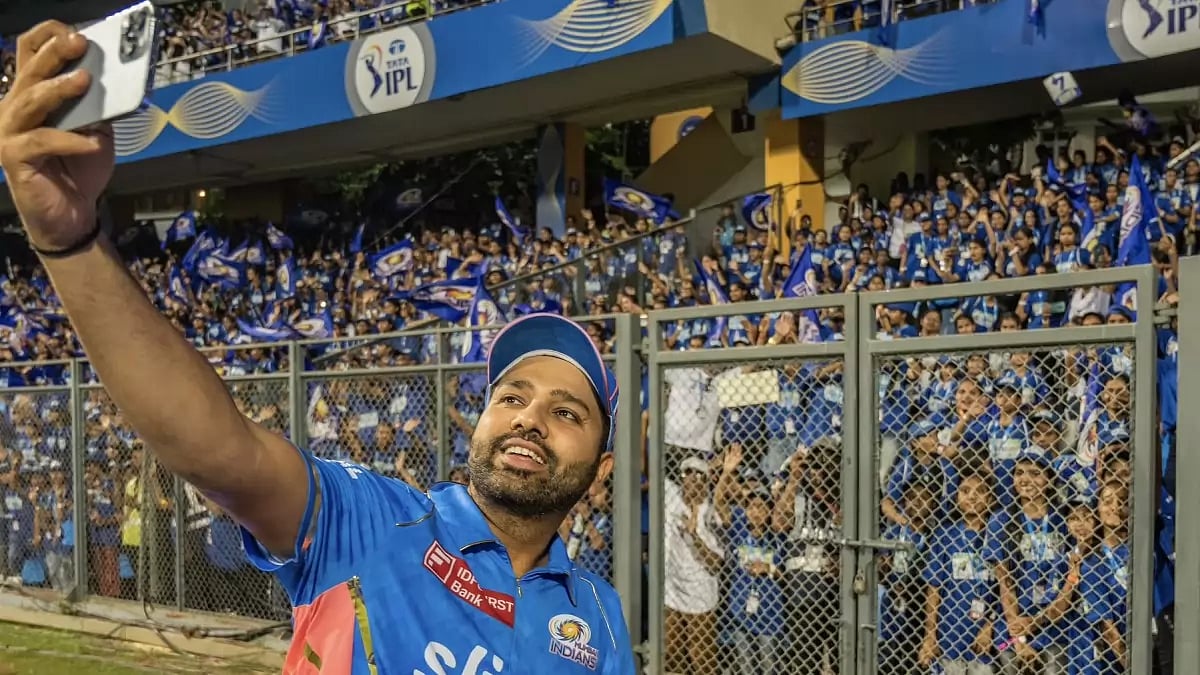 Mumbai Indians' Rohit Sharma clicks a selfie with spectators during IPL 2023. 