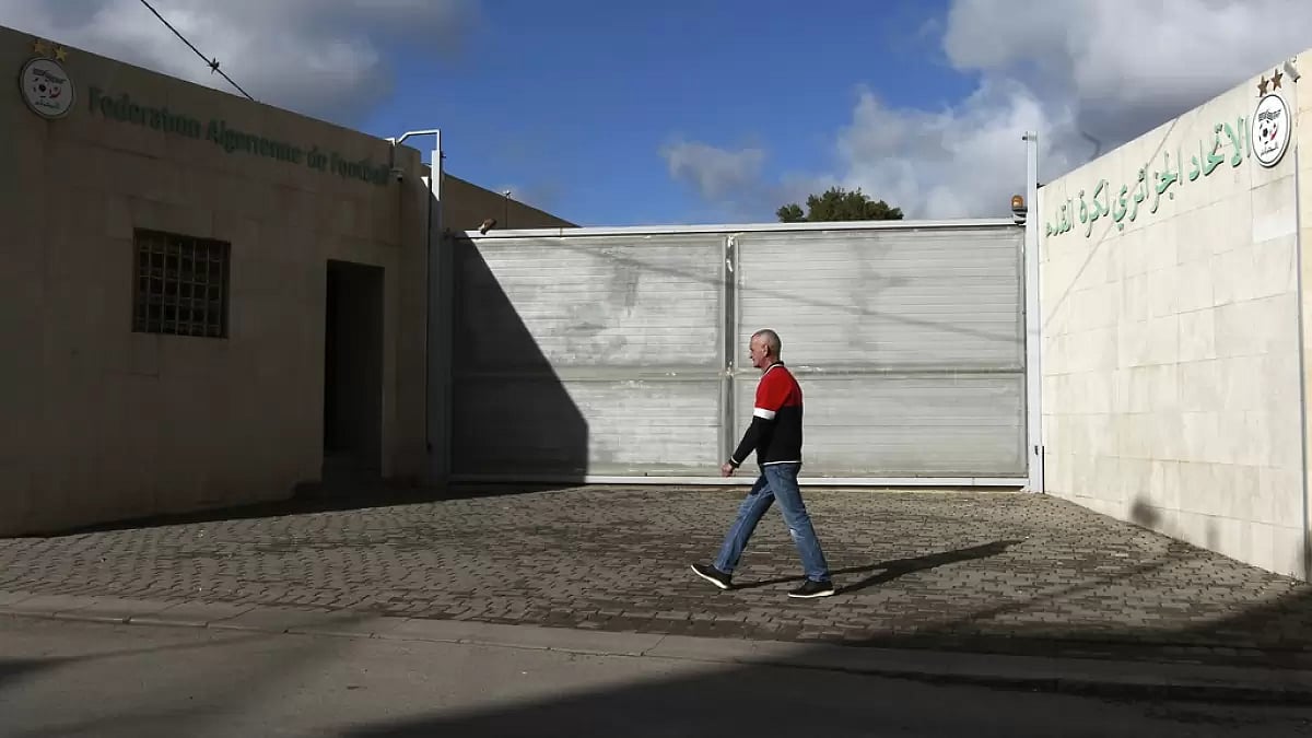 A man walks past the Algerian soccer federation after a bus crash killed two members of Ligue 1 side