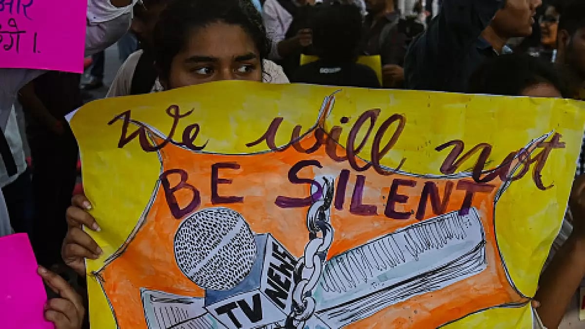 Activist in solidarity with arrested journalists holds a placard during a protest