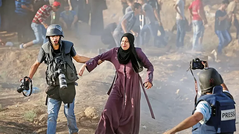 Caught in the Crosshairs: A press photographer rescues a woman from tear gas at a protest in Gaza - null