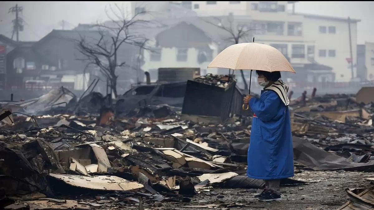 A woman looks at the burned-out marketplace by a fire following earthquakes in Wajima, Ishikawa pref
