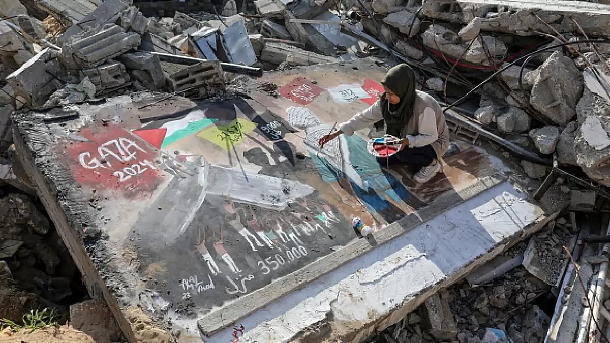Palestinian female artist is seen drawing a picture titled 'GAZA 2024' on the concrete of the rubble