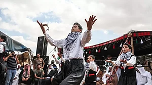 Palestinians perform Dabke at the a demonstration in Khas Yunis, Gaza