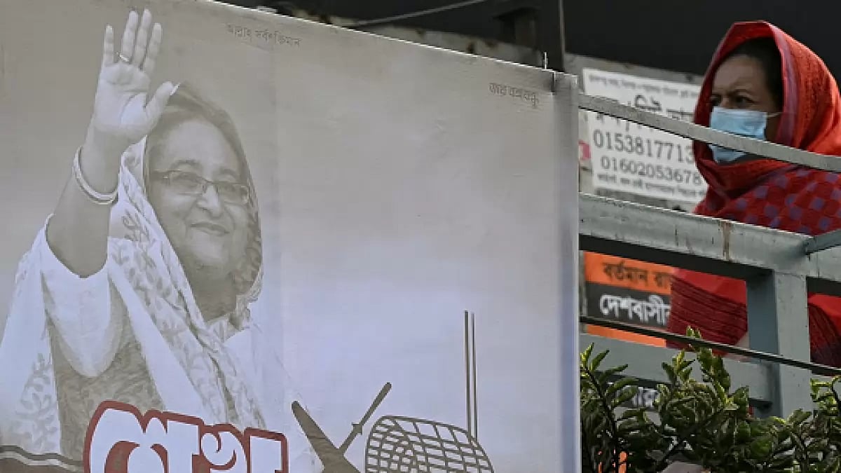 Pedestrian walking past Hasina poster