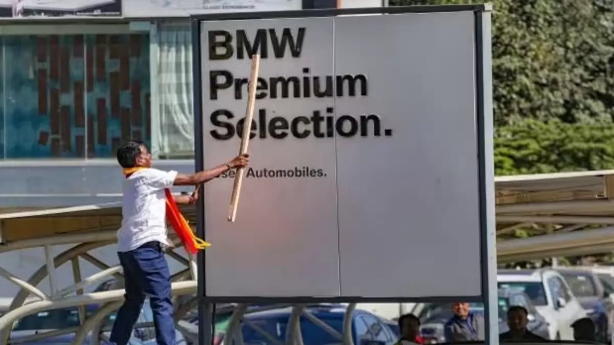 A pro-Kannada activist vandalizing an English language signboard in Bengaluru 