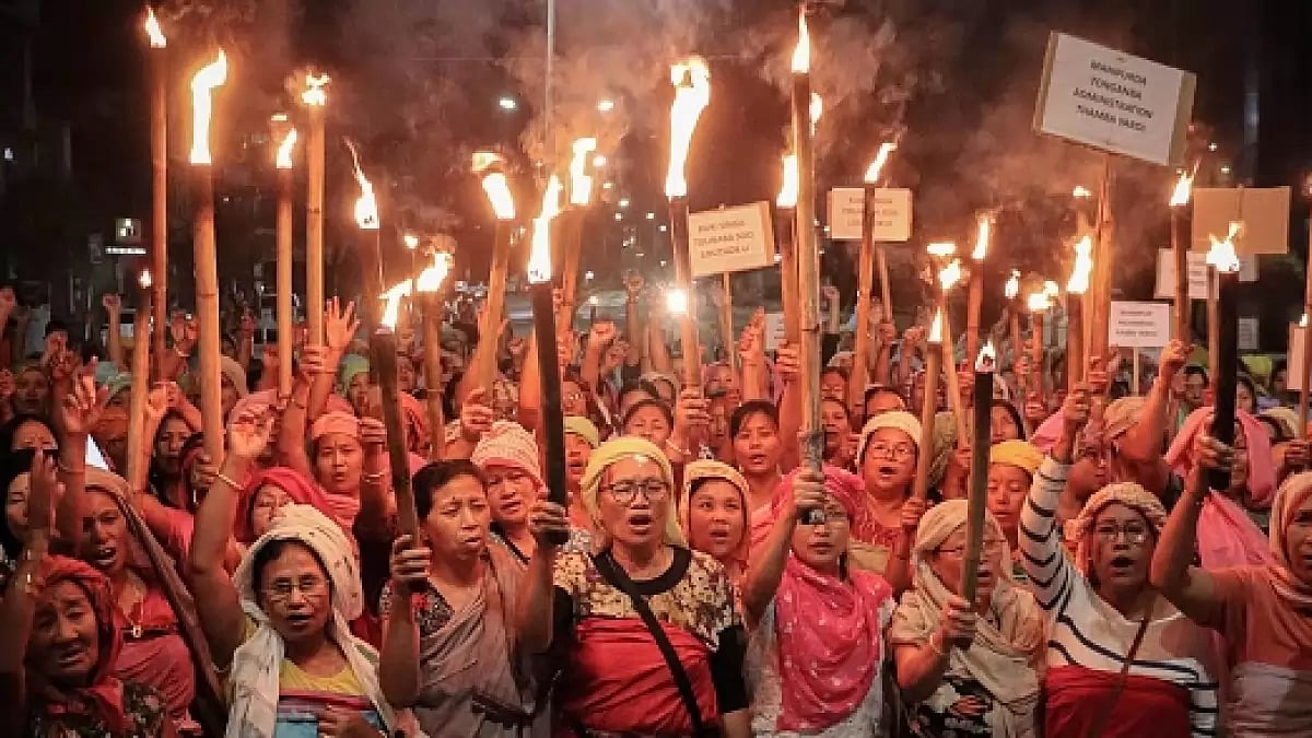 A group of women representing Meitei society, hold torches during a demonstration