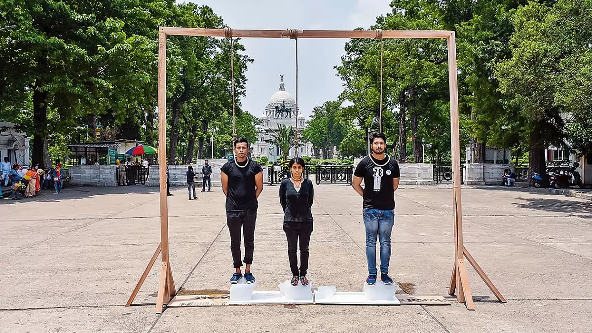 Activists standing on a block of ice with a noose tied around their neck as a sign of protest against global warming in Kolkata in 2022