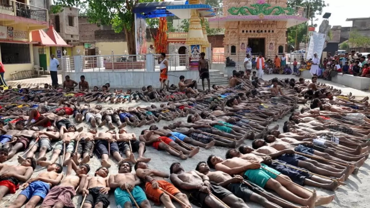  farmers lie on the ground with sticks as they pray for rain during the Manda Festival in Ranchi, Jharkhand