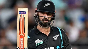 Daryl Mitchell raises his bat after scoring his half-century