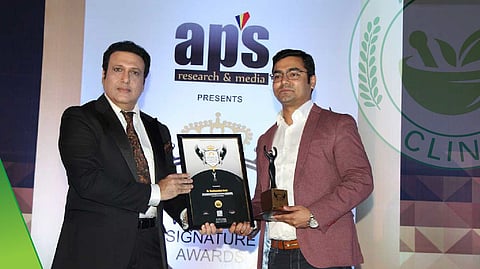 Dr Madhusudan receiving an award from Govinda