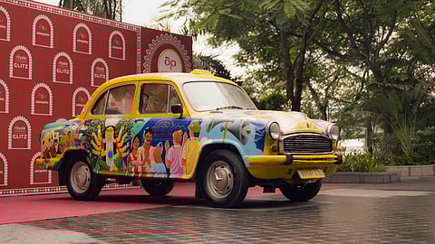 Yellow taxi in Kolkata decorated with retro-inspired designs for Durga Puja 2025, representing the 1985–1995 era