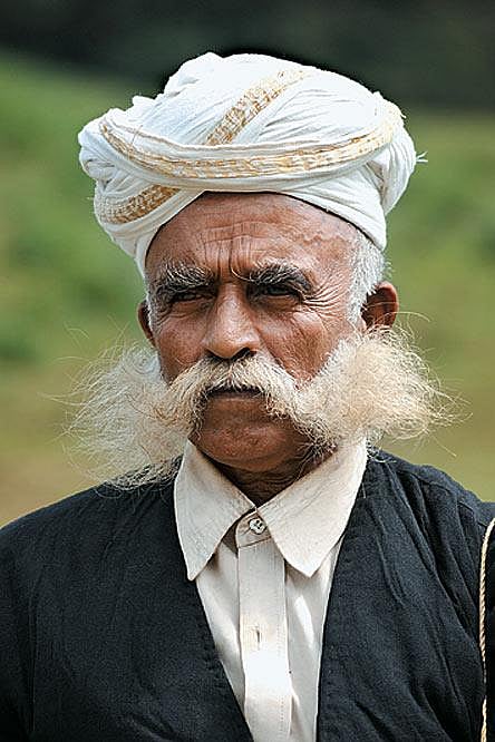 The ‘Kodava costume’ for men is called ‘Kupya’ which is a collar less half sleeve knee length jacket secured at waist with a maroon sash with gold embroidery called as ‘Chela’ and a knife is tucked into the ‘Chela’ that is referred to as ‘a peechekatti’ which represents their culture