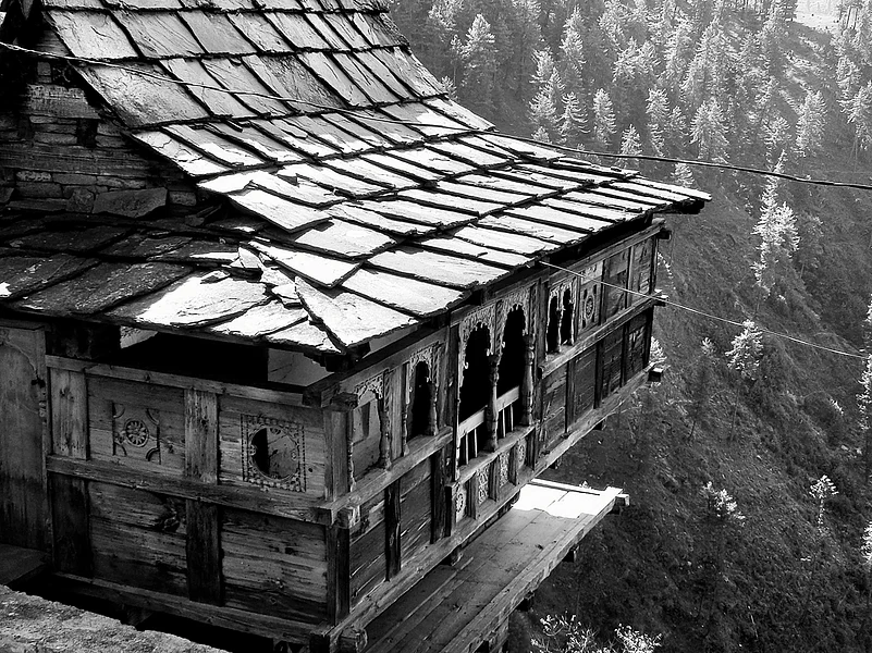 An alpine hut with slate roof tiles and pine panelling.