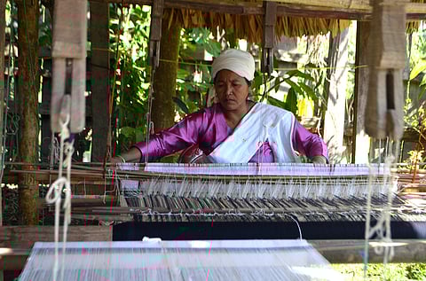 A Khampti woman weaving a pha-noi at her house in Emong village