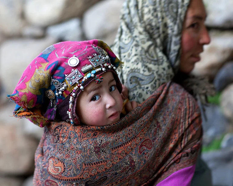 A Balti woman carrying her son - Storm Is Me / Shutterstock.com
