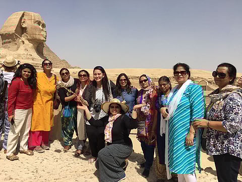 A travel group posing next to the Great Sphinx of Giza