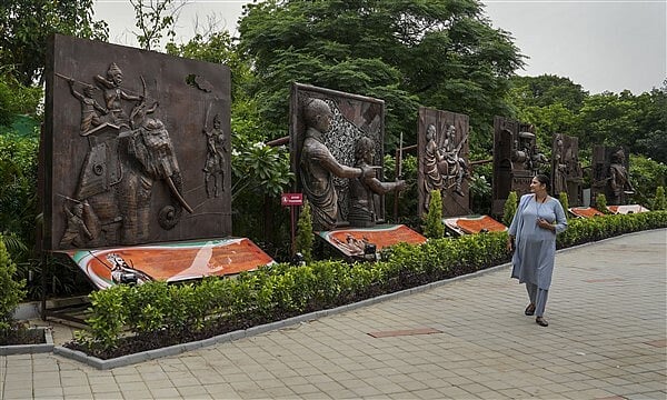oneindia.com : A woman walks along sculptures inside the park