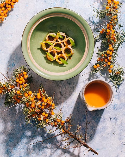 Sea buckthorn juice paired with 3 elements. A house-made veg XO sauce, roasted pineapple and squid, with a drizzle of fresh green pepper oil at Masque, Mumbai