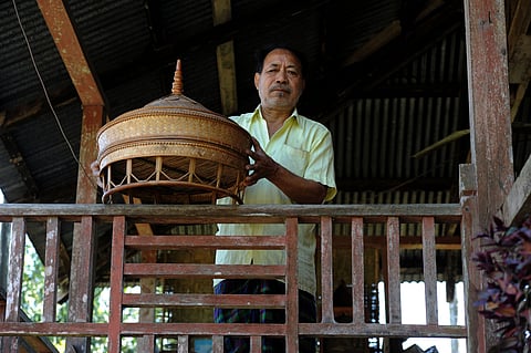 Chowkim Singpho with a phon that he has made.