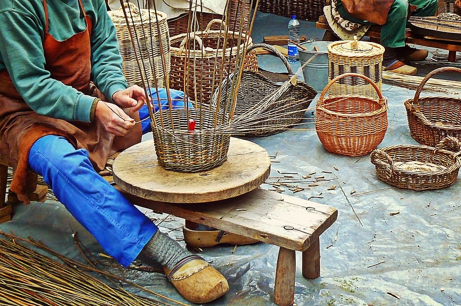 A craftsperson works on weaving baskets from rattan and bamboo