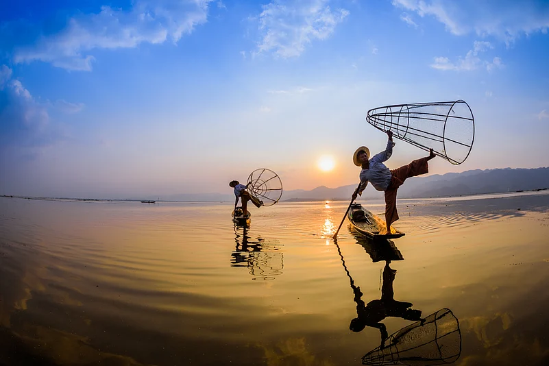 Fishermen at Inle Lake rowing bats with one leg