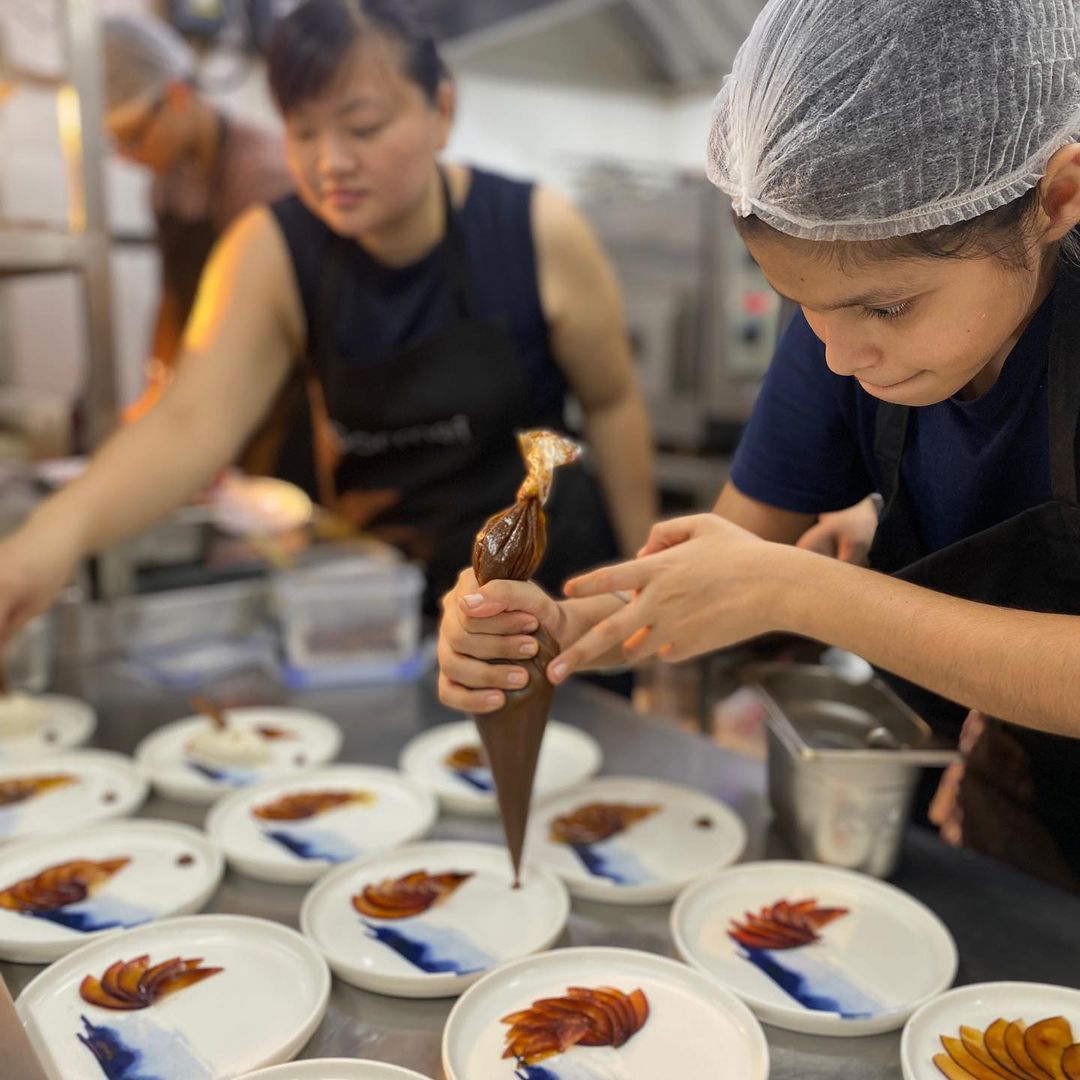 Chef Katherine Chung (in background) cooking at Cobbler And Crew