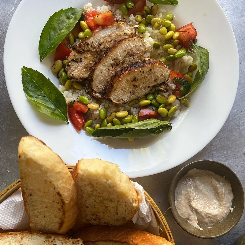 A take on couscous salad but with corn grits, edamame, pan seared chicken breast, tomatoes, basil & mint, with a side of tahini & fresh bread