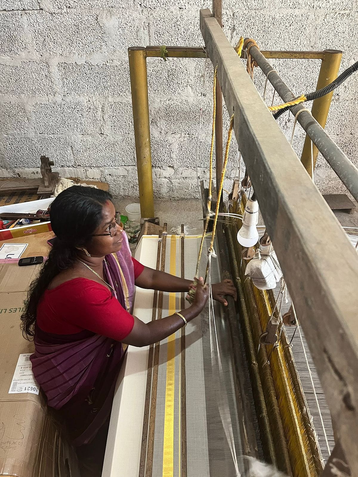 A lady weaving the traditional kasavu
