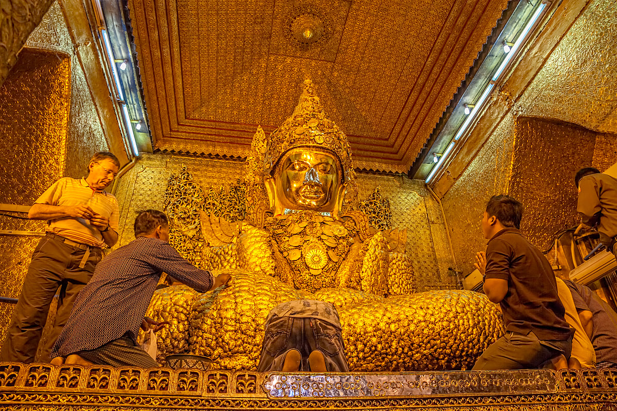 Devotees putting gold leaves in Mahamuni Buddha Temple