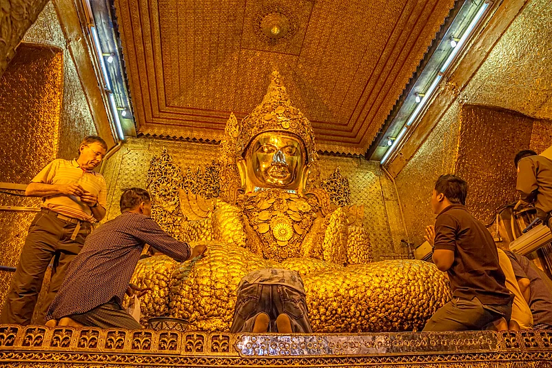 Devotees putting gold leaves in Mahamuni Buddha Temple
