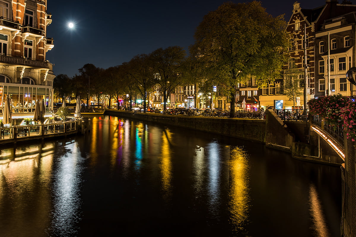 Night view in Amsterdam from Doelensluis bridge across the Amstel river