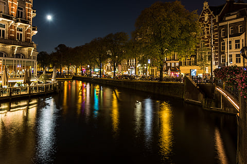 Night view in Amsterdam from Doelensluis bridge across the Amstel river
