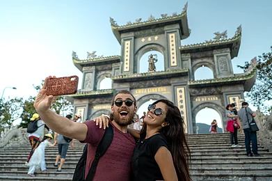 Shutterstock : Happy tourist couple taking a selfie in Da Nang Vietnam