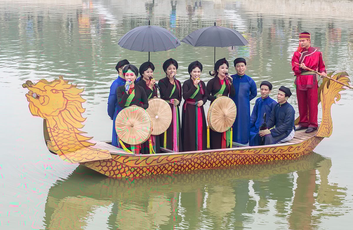 Men and women singing quan họ folk songs from dragon boats