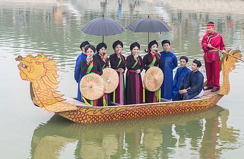 Men and women singing quan họ folk songs from dragon boats