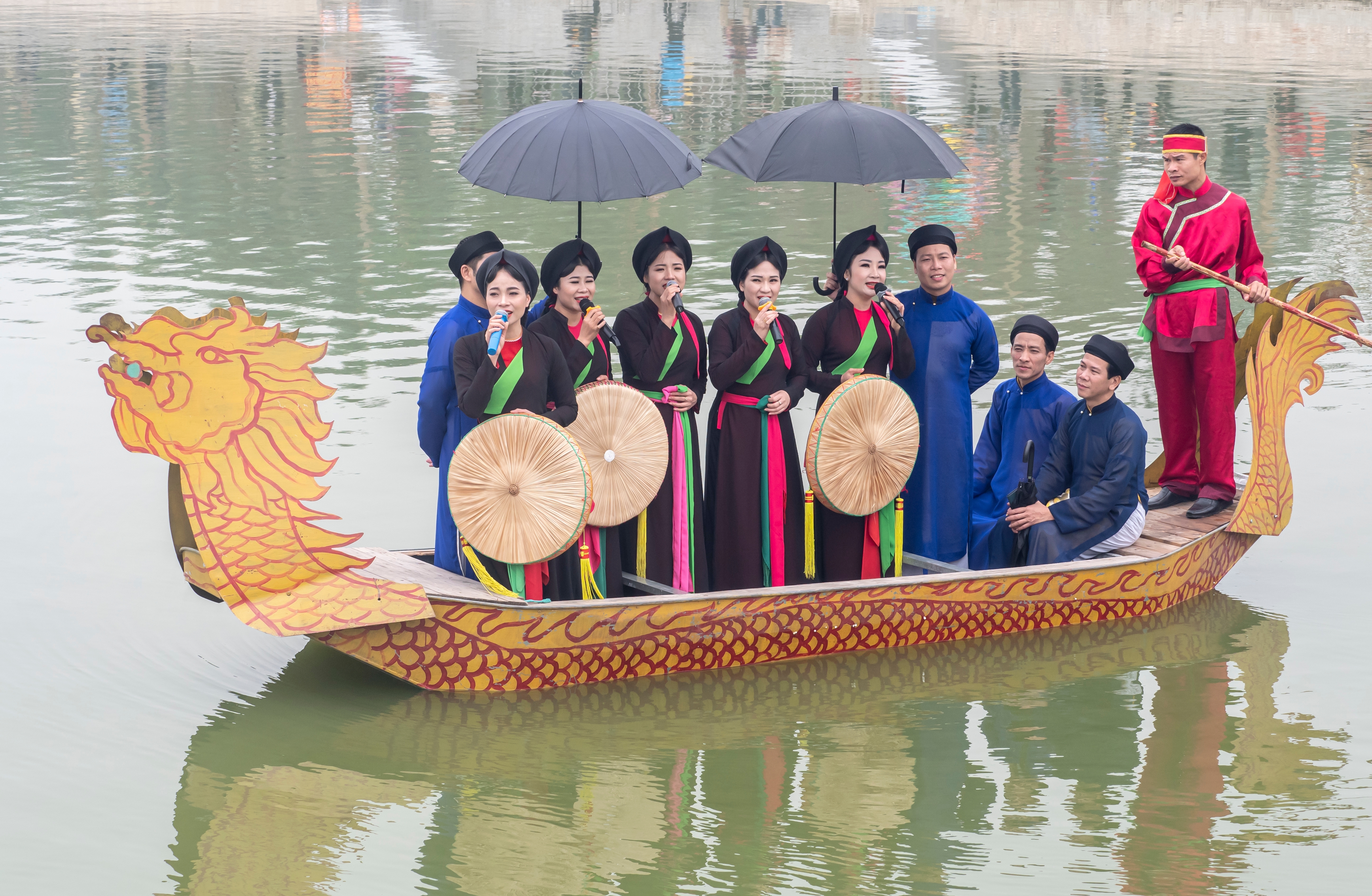 Men and women singing quan họ folk songs from dragon boats