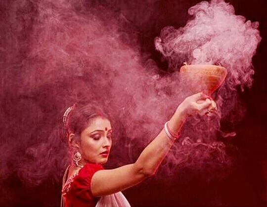 The dhunuchi is has burning coal under a layer of coconut husk sprinkled with frankincense