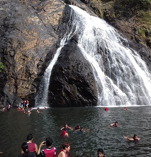 Tourists enjoying a swim at the waterfall