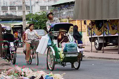A cyclo driver peddling his passenger