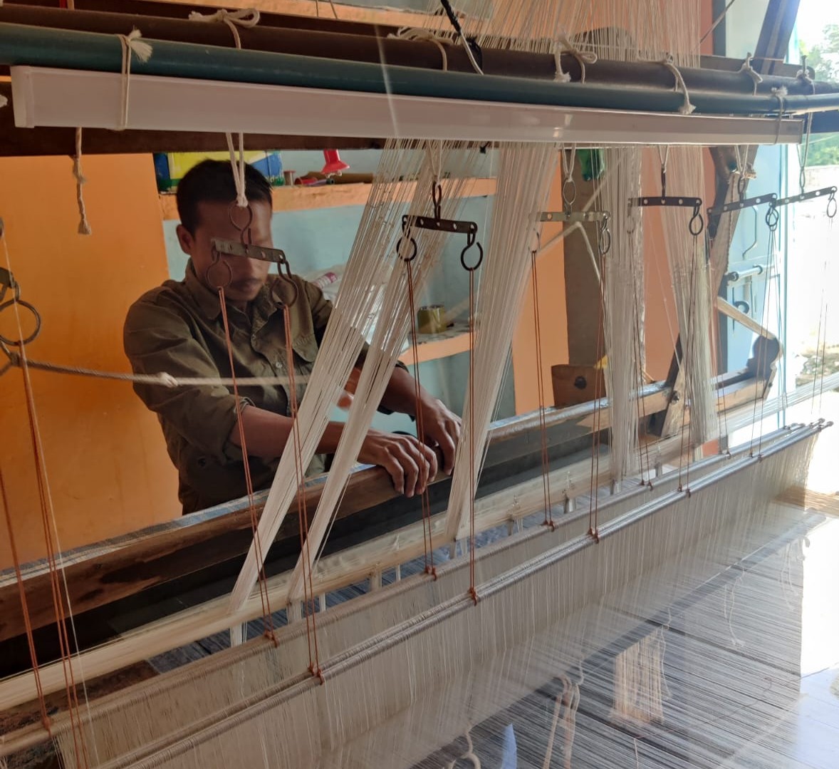 A weaver at work on a handloom in Pranpur