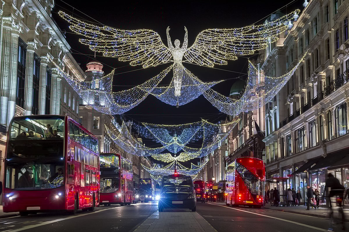 Shutterstock : Red double-decker buses pass under twinkling Christmas lights 
